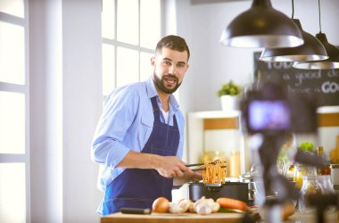 Mutfak arka planında poşet dolusu erzak tutan adam. Alışveriş ve sağlıklı gıda konsepti