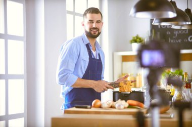 Mutfak arka planında poşet dolusu erzak tutan adam. Alışveriş ve sağlıklı gıda konsepti