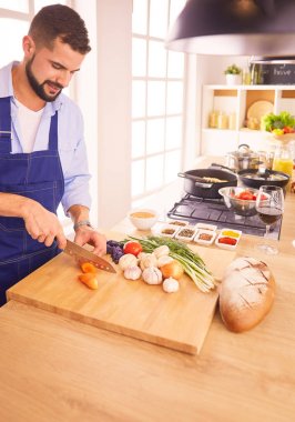 Adam ev mutfağında lezzetli ve sağlıklı yemekler hazırlıyor.