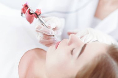 Kırmızı dudaklı genç bir kız kalıcı makyaj, mikro pigmentasyon