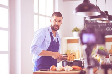 Mutfak arka planında poşet dolusu erzak tutan adam. Alışveriş ve sağlıklı gıda konsepti