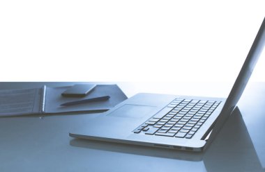 Kahve fincanı, dizüstü bilgisayar, dizüstü bilgisayar, gözlük ve hesap makinesi içeren ofis masası.