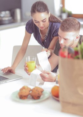 Çift evde mutfak içinde laptop ile onların fatura ödeme