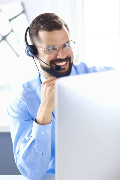 Biznesmen w biurze przez telefon z słuchawkami, Skype, FaceTime — Zdjęcie stockowe