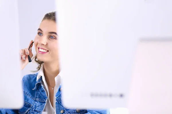 Feliz encantadora joven sentada y trabajando con el ordenador portátil con auriculares en la oficina —  Fotos de Stock