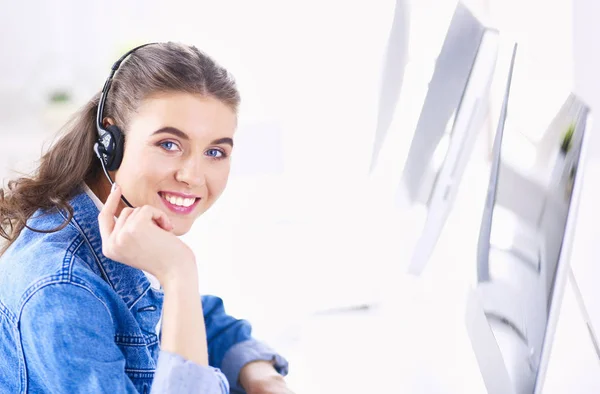 Retrato de mulher de negócios bonita trabalhando em sua mesa com fone de ouvido e laptop — Fotografia de Stock