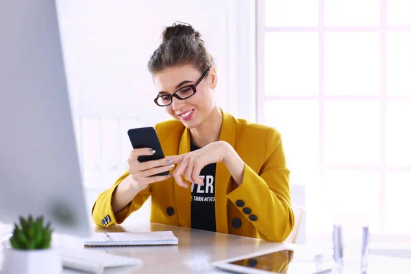 Donna d'affari seduta in ufficio con computer portatile al telefono — Foto Stock