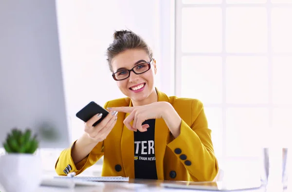 Donna d'affari seduta in ufficio con computer portatile al telefono — Foto Stock