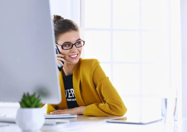 Zakenvrouw zitten in kantoor met laptop op telefoon — Stockfoto