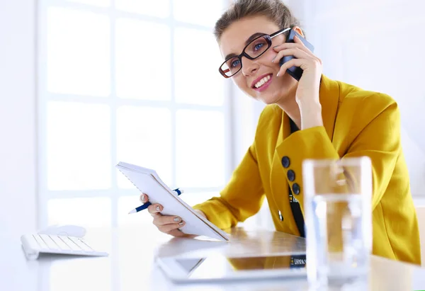 Donna d'affari che si concentra sul lavoro, utilizzando il computer e il cellulare in ufficio — Foto Stock