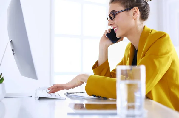 Donna d'affari che si concentra sul lavoro, utilizzando il computer e il cellulare in ufficio — Foto Stock