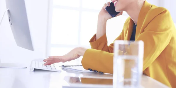 Empresaria concentrándose en el trabajo, usando computadora y celular en la oficina —  Fotos de Stock