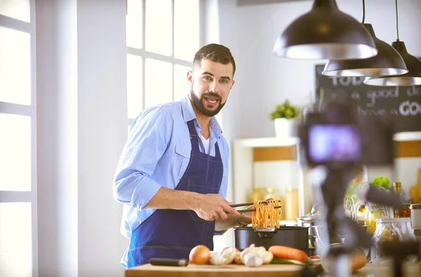 Mann hält Papiertüte voller Lebensmittel auf dem Küchenhintergrund. Shopping und gesundes Ernährungskonzept — Stockfoto