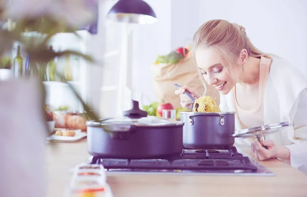 Wanita muda yang cantik memasak di dapur di rumah — Stok Foto