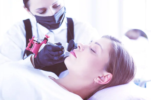 Cosmetologist aplicando a composição permanente nas sobrancelhas — Fotografia de Stock