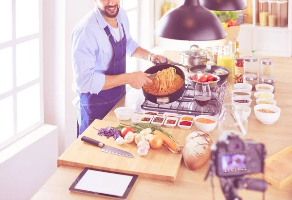 Man holding paper bag full of groceries on the kitchen background. Shopping and healthy food concept — Stock Photo, Image