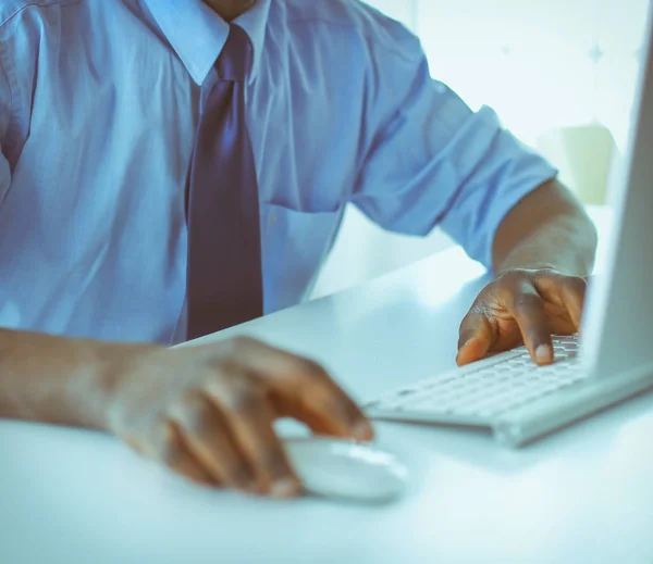 Afrikansk amerikansk affärsman på headset arbetar på sin bärbara dator — Stockfoto