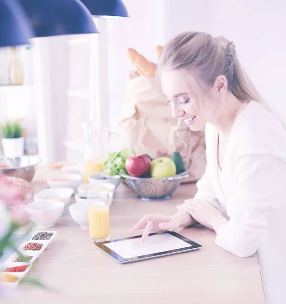 Hermosa joven usando una tableta digital en la cocina —  Fotos de Stock