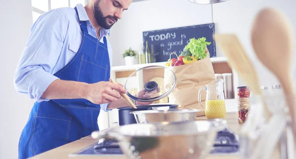 Uomo che prepara cibo delizioso e sano nella cucina di casa — Foto Stock