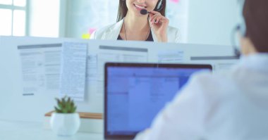 Ofisinde kulaklık ve bilgisayarla gülümseyen iş kadını ya da yardım hattı operatörü