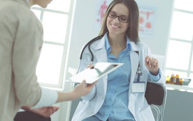 Doktor ve hasta masada otururken bir şey tartışıyorlar. Tıp ve sağlık hizmetleri kavramı. Doktor ve hasta.