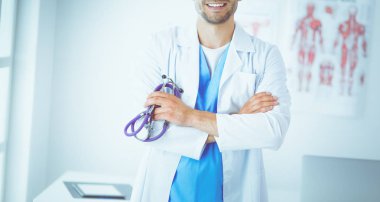 Elinde kahve fincanı olan genç bir doktor.