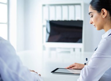 Başarılı tıp doktorları konferans boyunca belgeleri tartışıyor ve gülümsüyor.