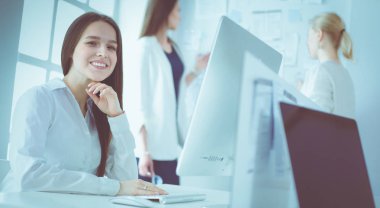 Ofiste dizüstü bilgisayarda çalışan çekici kadın. İş adamları