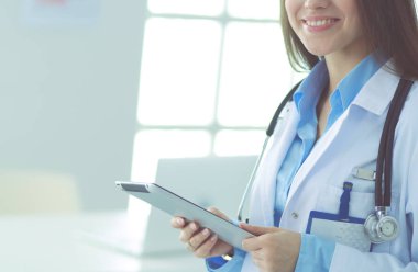 Hastane lobisinde tablet bilgisayar kullanan kadın doktor.