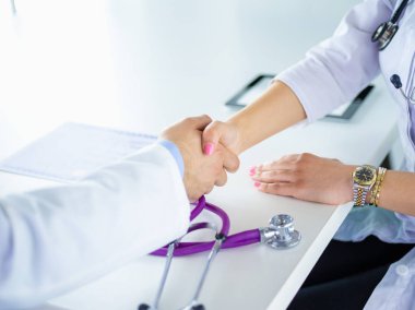 Genç tıpçılar ofiste el sıkışıyor.