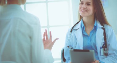 Doktor ve hasta masada otururken bir şey tartışıyorlar. İlaç ve sağlık hizmetleri kavramı