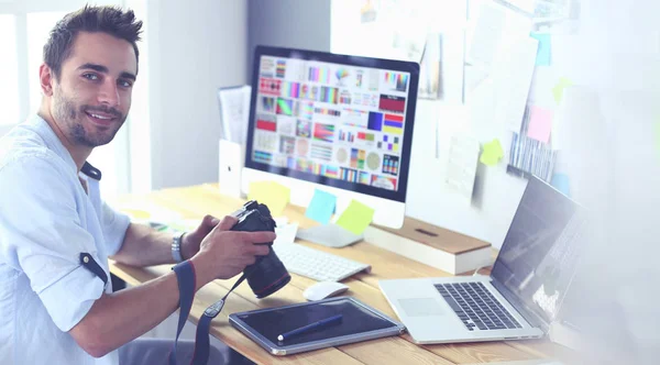 Retrato de jovem designer sentado no estúdio gráfico na frente de laptop e computador enquanto trabalhava online. — Fotografia de Stock