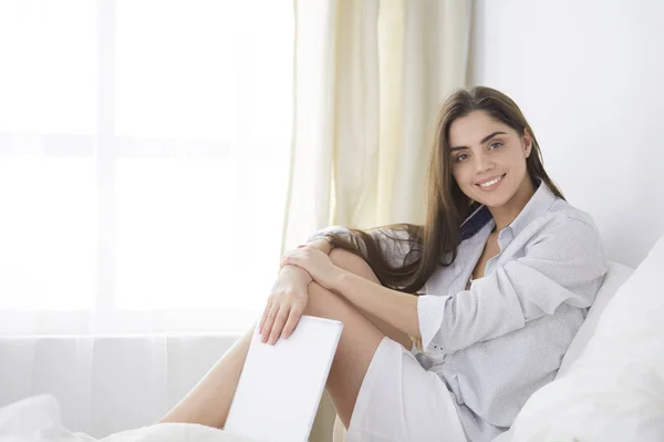 Retrato de la mujer usando tableta y tomando café mientras está sentada en la cama por la mañana — Foto de Stock