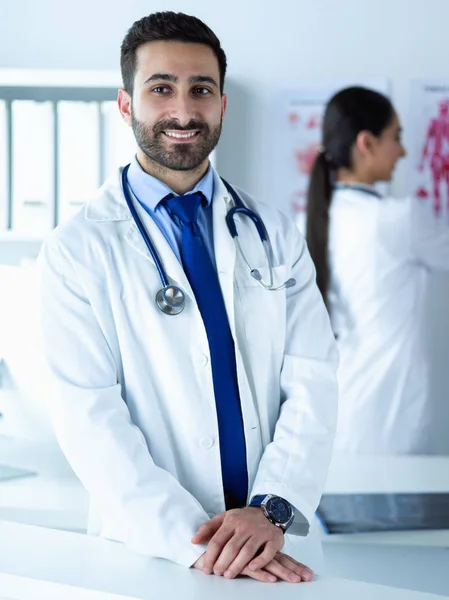 Attractive male doctor in front of medical group — Stock Photo, Image