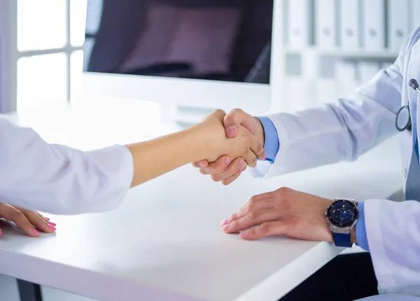 Doctor estrechando la mano al paciente en la oficina en el escritorio — Foto de Stock