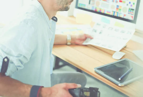 Portrét mladého návrháře sedícího v grafickém studiu před notebookem a počítačem při práci online. — Stock fotografie