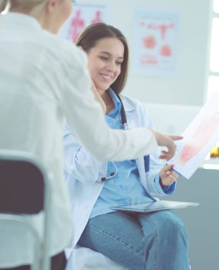 Doktor ve hasta masada otururken bir şey tartışıyorlar. İlaç ve sağlık hizmetleri kavramı
