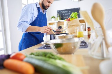 Adam ev mutfağında lezzetli ve sağlıklı yemekler hazırlıyor.