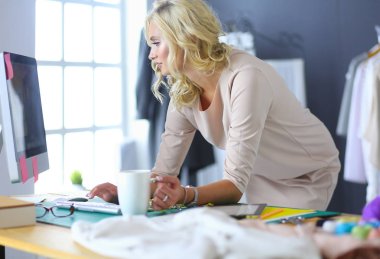 Moda tasarımcısı kadın stüdyoda tasarımları üzerinde çalışıyor..