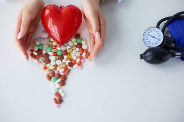 Masada kırmızı kalbi ve steteskopu olan kardiyolog.