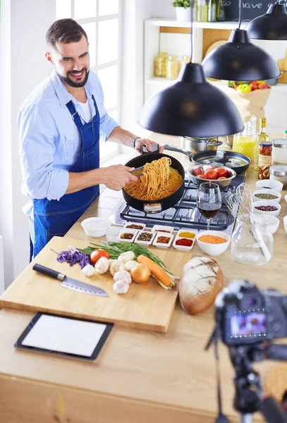 Man holding paper bag full of groceries on the kitchen background. Shopping and healthy food concept — Stock Photo, Image