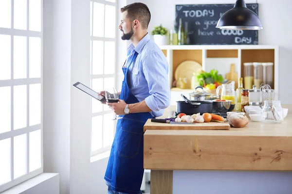 Man efter recept på digital tablett och matlagning välsmakande och hälsosam mat i köket hemma — Stockfoto