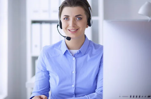 Ernsthafte hübsche junge Frau arbeitet als Telefonistin mit Headset im Büro — Stockfoto