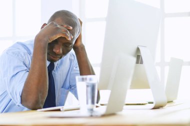 Kulaklıklı Afro-Amerikan işadamı laptopuyla çalışıyor.