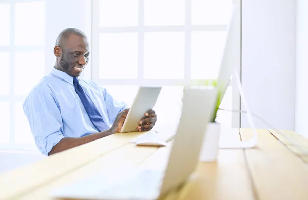 Afrikansk amerikansk affärsman på headset arbetar på sin bärbara dator — Stockfoto