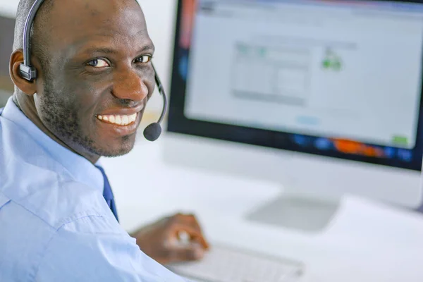 African american businessman on headset working on his laptop — Stock Photo, Image