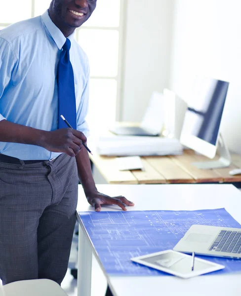 Arquitecto afroamericano trabajando con computadoras y planos en la oficina — Foto de Stock