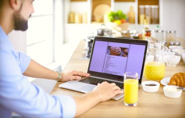 Adam ev mutfağında lezzetli ve sağlıklı yemekler hazırlıyor.