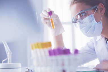Modern laboratuvar veya hastanede plastik tıbbi tüplerle çalışan araştırmacı, doktor, bilim adamı veya laboratuvar asistanı