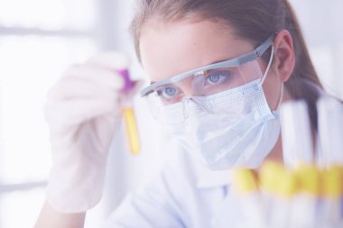 Modern laboratuvar veya hastanede plastik tıbbi tüplerle çalışan araştırmacı, doktor, bilim adamı veya laboratuvar asistanı